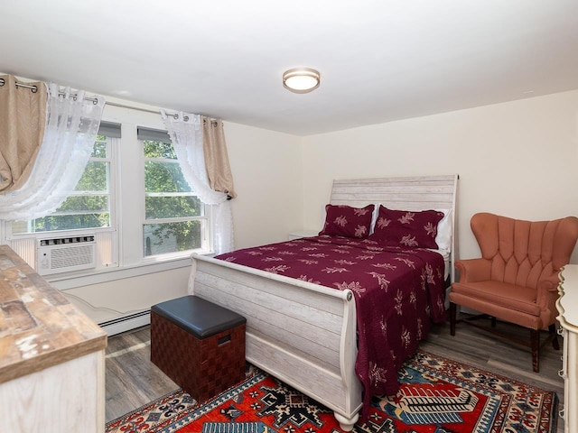 bedroom with a baseboard radiator, wood finished floors, and cooling unit