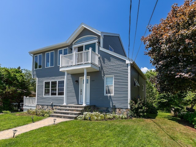 view of front of house featuring a front yard and a balcony
