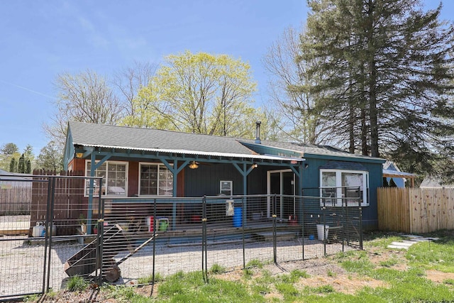 view of front of property featuring a shingled roof and fence