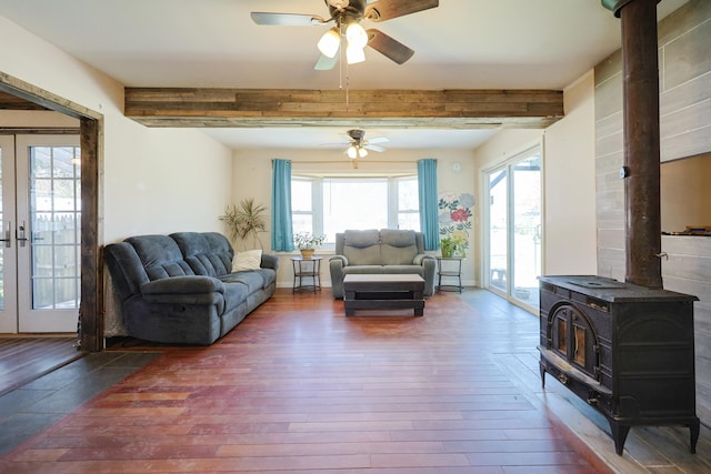 living area featuring a wood stove, ceiling fan, a wealth of natural light, and hardwood / wood-style floors