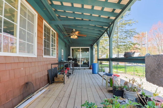 wooden terrace with a ceiling fan and a grill