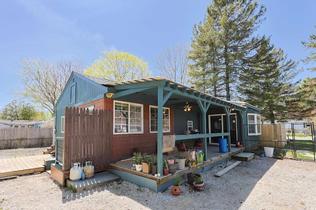 view of home's exterior featuring fence, a wooden deck, and ceiling fan