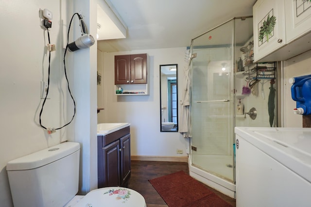 bathroom with washer / clothes dryer, toilet, a shower stall, and vanity