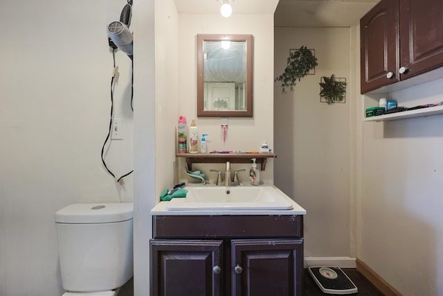 half bathroom featuring vanity and toilet