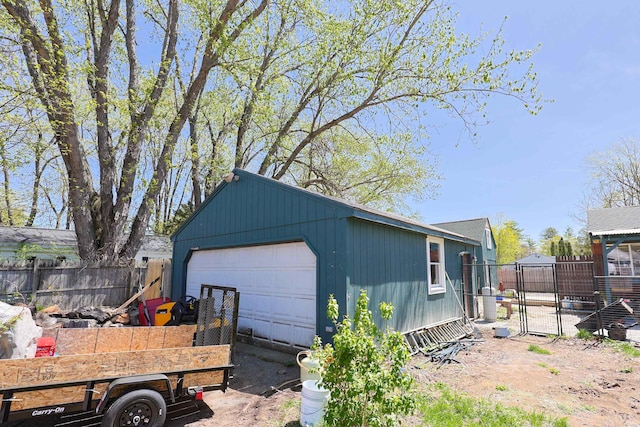 detached garage featuring fence and a gate