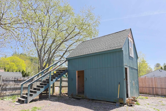 view of outdoor structure with an outdoor structure, fence, and stairs