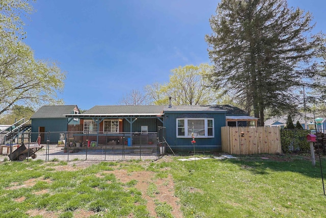 back of house featuring a yard, a patio, and fence
