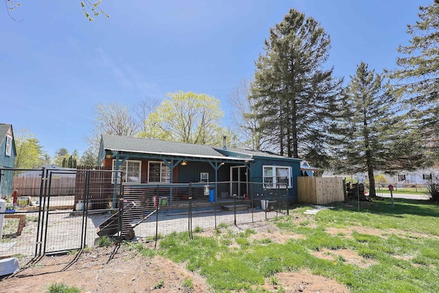 back of property with a gate and fence