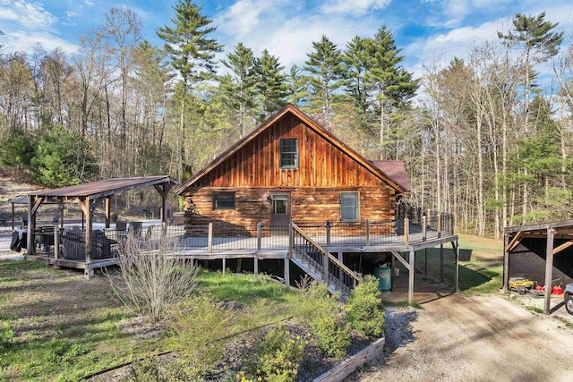 view of front of house featuring a gazebo, a wooden deck, log siding, and metal roof