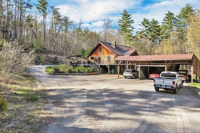 cabin featuring driveway and metal roof