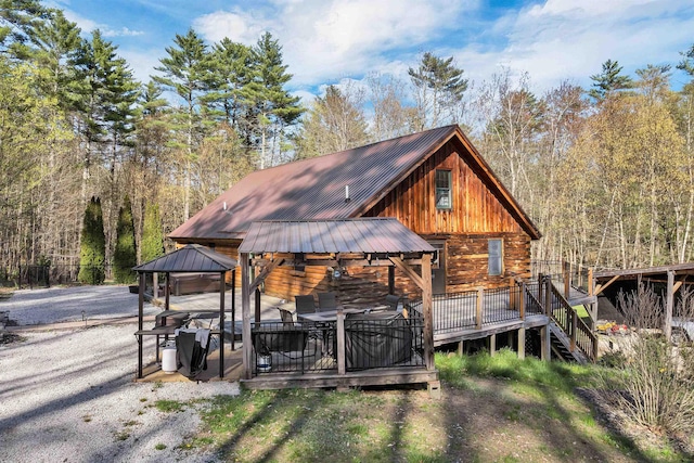 exterior space with a gazebo and a wooded view