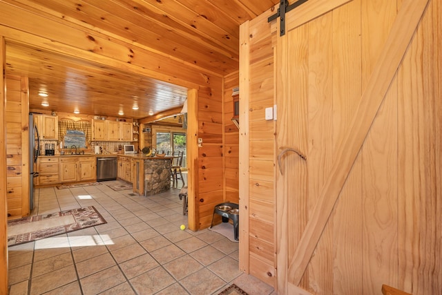 interior space featuring a sink, wood ceiling, stainless steel appliances, and a barn door