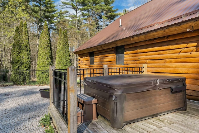 wooden terrace featuring a hot tub and fence