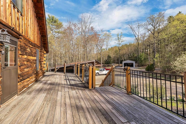 wooden terrace featuring an outdoor structure and a shed