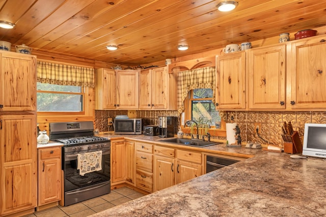 kitchen with light brown cabinets, light tile patterned floors, a sink, backsplash, and stainless steel appliances