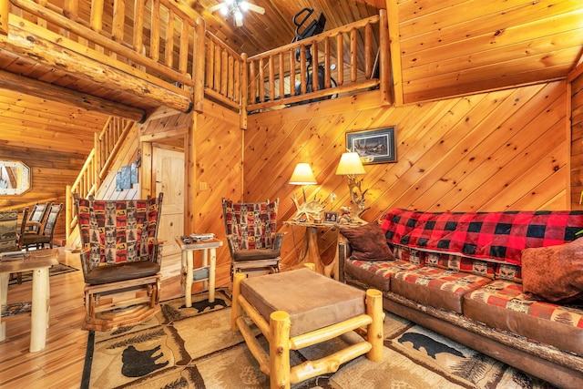 living area with wood walls, wood ceiling, wood finished floors, and beamed ceiling
