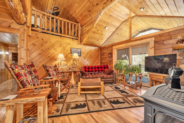 living area featuring wood walls, vaulted ceiling, wooden ceiling, and light wood finished floors