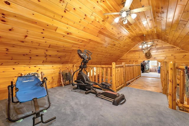 exercise room with wood walls, carpet, a ceiling fan, and vaulted ceiling