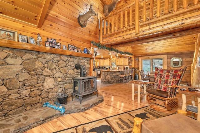 living room featuring wooden walls, a wood stove, and wood finished floors