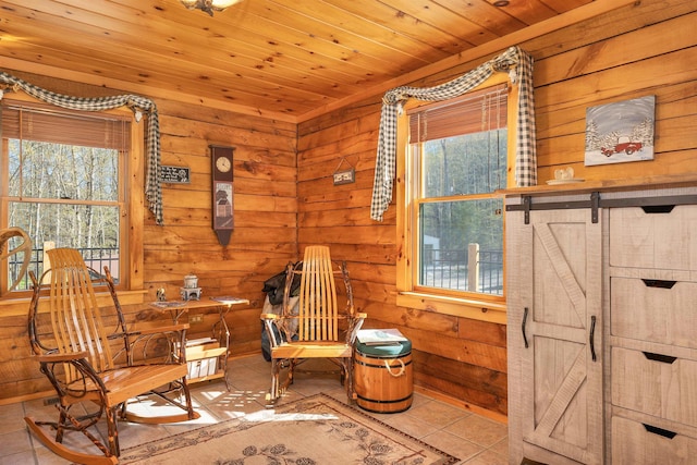 sitting room with wood walls, wood ceiling, tile patterned floors, and a wealth of natural light