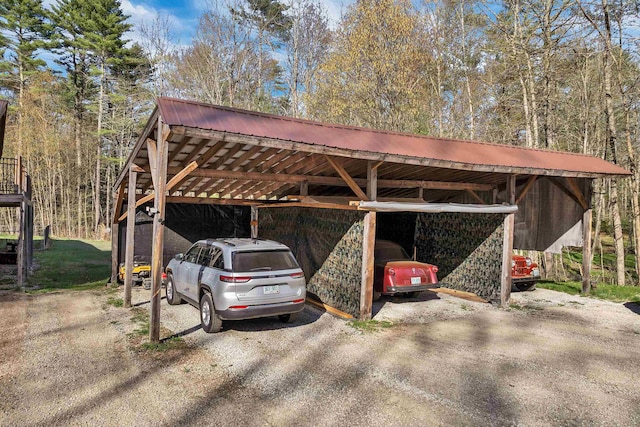 view of car parking with dirt driveway and a carport