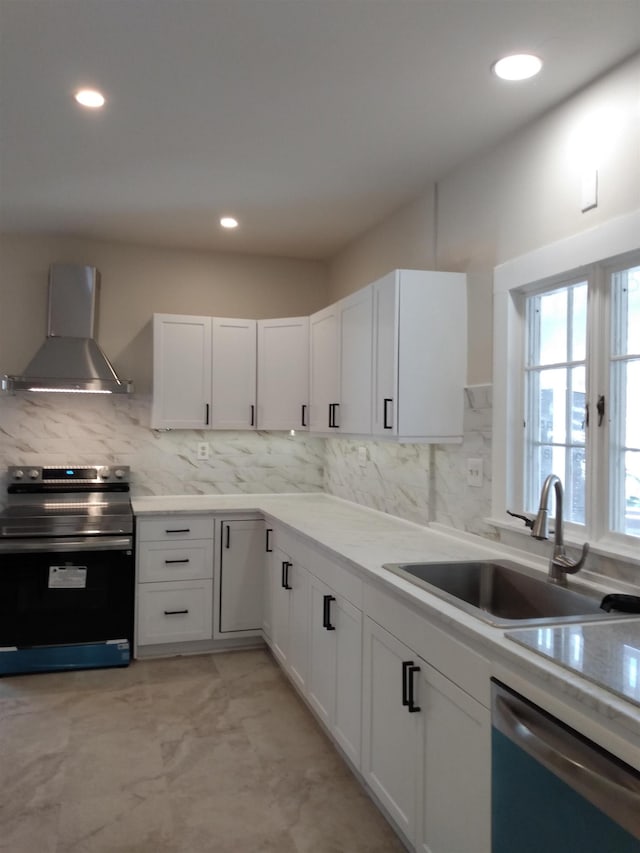 kitchen with stainless steel electric range oven, dishwasher, a sink, white cabinets, and wall chimney exhaust hood