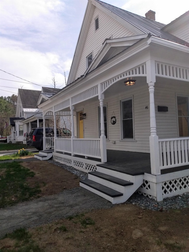view of front of home featuring a porch and a chimney