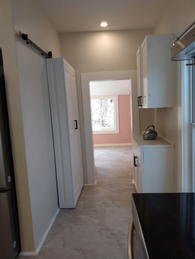 hallway with recessed lighting, baseboards, and a barn door