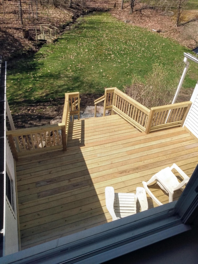 wooden deck featuring a lawn