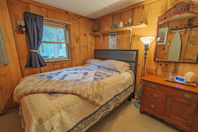 bedroom with wooden walls and light colored carpet
