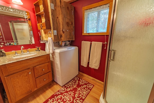 laundry area with a sink, baseboards, laundry area, and light wood-style flooring