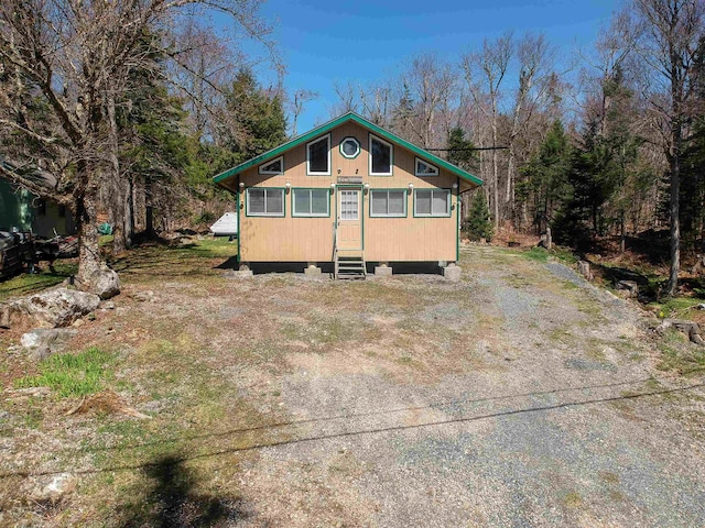 back of house with a wooded view and entry steps