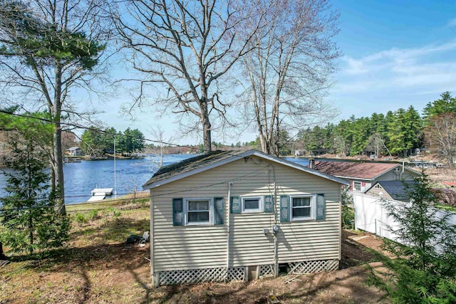 view of property exterior with fence and a water view