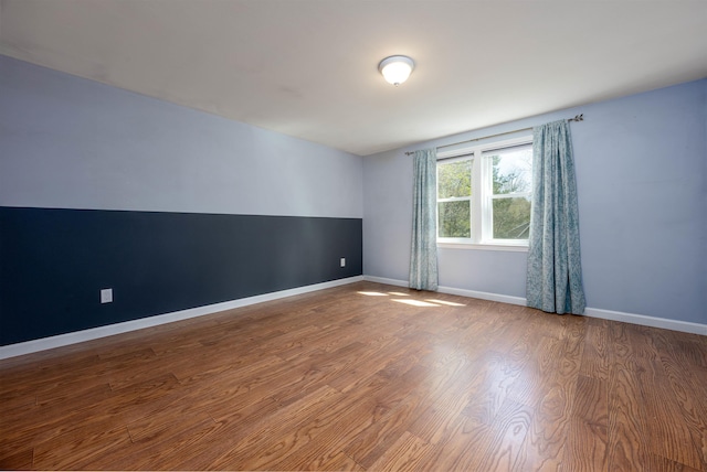 empty room featuring baseboards and wood finished floors