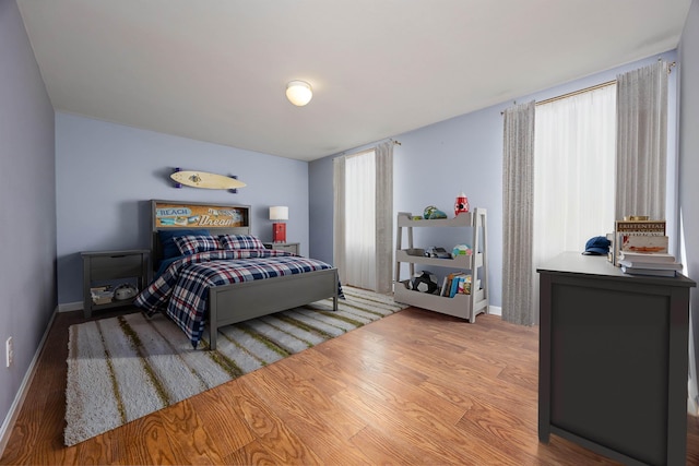 bedroom with baseboards and wood finished floors