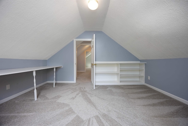 bonus room with carpet floors, a textured ceiling, and vaulted ceiling