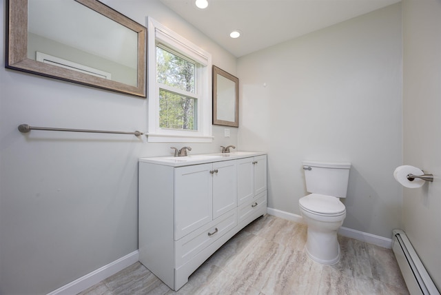 bathroom with double vanity, toilet, baseboards, recessed lighting, and a baseboard heating unit