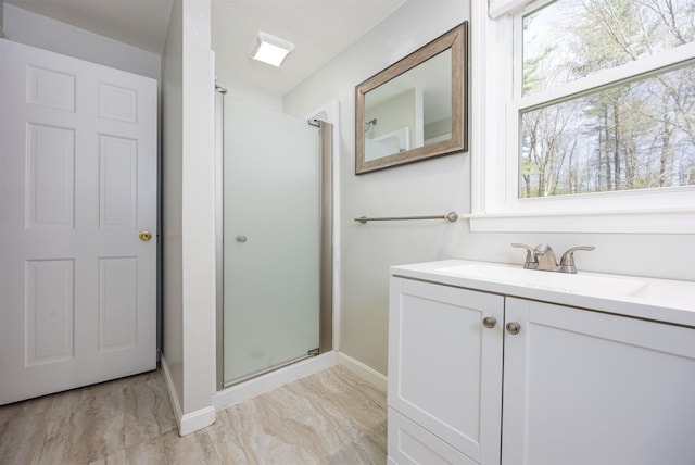 full bath featuring baseboards, a shower stall, and vanity
