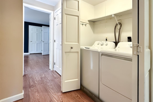 laundry room with laundry area, independent washer and dryer, and wood finished floors