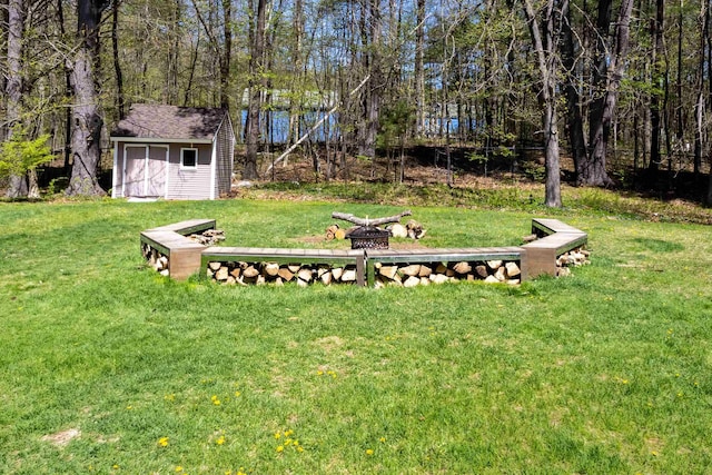 view of yard with a fire pit and an outbuilding