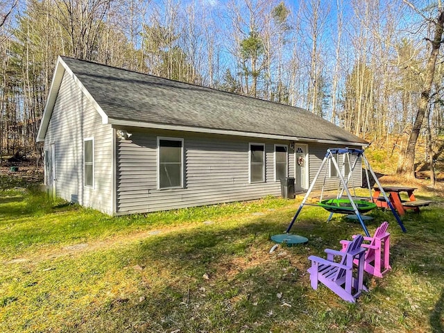 view of front of home featuring a shingled roof and a front lawn