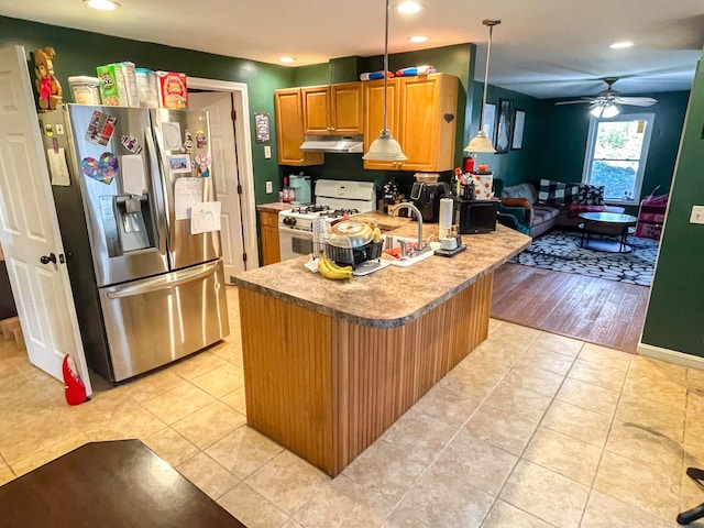 kitchen featuring stainless steel fridge with ice dispenser, recessed lighting, white range with gas stovetop, light tile patterned floors, and under cabinet range hood