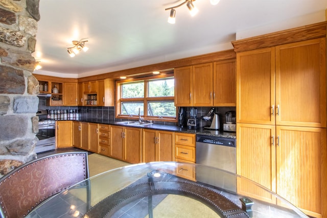 kitchen with a sink, decorative backsplash, appliances with stainless steel finishes, and brown cabinets