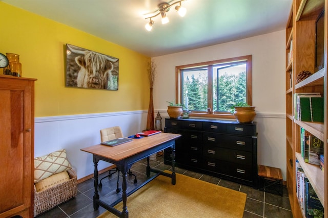 office featuring dark tile patterned flooring and a wainscoted wall