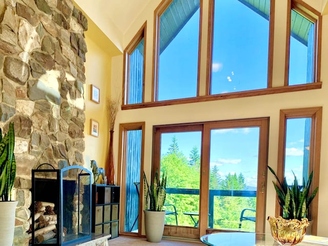 entryway featuring a fireplace and high vaulted ceiling