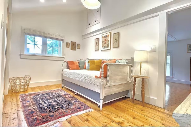 bedroom featuring high vaulted ceiling, baseboards, and wood-type flooring