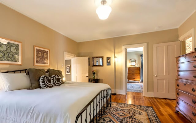 bedroom featuring baseboards and wood finished floors