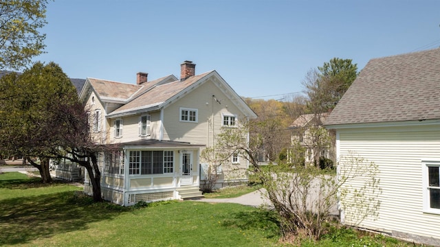 rear view of house with a lawn and a chimney