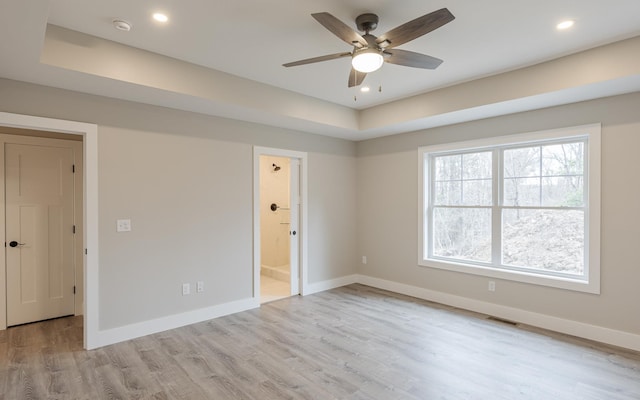 spare room featuring baseboards, visible vents, ceiling fan, and light wood-type flooring