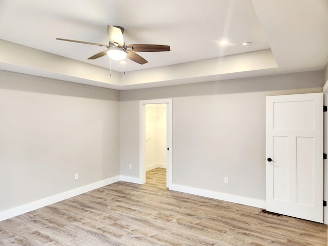 unfurnished room with light wood-style floors, baseboards, and ceiling fan